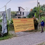 Spanduk peringatan yang dipasang ahli waris di atas tanah yang belum dilunasi pengembang. Foto: Ist