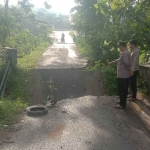 Petugas dari Polsek Kokop saat meninjau jembatan yang ambruk.