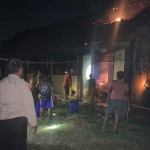 Warga berupaya memadamkan api dengan alat seadanya saat kebakaran terjadi.