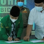 Ketua PC GP Ansor Kabupaten Kediri, Rizmi Haitami Azizi saat menandatangani kerja sama dengan BPJS Ketenagakerjaan.  foto: ist.