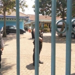 Petugas bersenjata berjaga di gerbang kantor DPU SDA Kabupaten Malang.