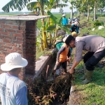 Anggota Polsek Ngawi, bersama warga membersihkan saluran irigasi persawahan di Desa Tempuran, Kecamatan Paron, Ngawi, Minggu (23/10/2022).