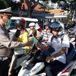 Jajaran Polres Pamekasan saat membagikan masker dan hand sanitizer di persimpangan jalan Jokotole Pamekasan.