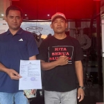 Korban saat menunjukkan bukti laporan ke Polres Pasuruan.