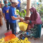 BERBAGI: M Taufiqulbar membagikan sembako di Desa Banjar Kemuning Sedati, Jumat (24/4). foto: MUSTAIN/ BANGSAONLINE