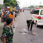 Petugas saat mengevakuasi korban kecelakaan di Jalan Raya Bypass Krian, Sidoarjo.