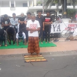 Pengunjuk rasa melaksanakan salat berjamaah di depan gerbang kantor Gubernur Jawa Timur. foto: DIDI ROSADI/ BANGSAONLINE