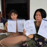  Yunanik (kanan) bersama adik dan suami saat menunjukkan bukti rekening koran dan laporan ke Polda Jatim. Foto: SUWANDI/ BANGSAONLINE