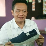 Ronny Wahyono dengan salah satu sneakers koleksinya. foto: YUNIARDI S/ BANGSAONLINE