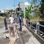 Para pekerja sedang merampungkan proyek perbaikan jalan Hasanudin, Junrejo, Kota Batu.