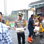 Kapolres Gresik (tengah) saat menyerahkan bantuan kepada korban terdampak banjir di Driyorejo. Foto: Ist