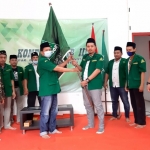 Ketua PAC GP Ansor Genteng terpilih, Badrus Sholeh menerima pataka GP Ansor dari Muhammad Mundir, Wakil Ketua Pimpinan Cabang GP Ansor Surabaya. foto: istimewa