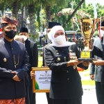 Gubernur Khofifah saat menyerahkan piala Juara Umum dalam Turnamen Olahraga BUMD kepada Dirut Bank Jatim, Busrul Iman.