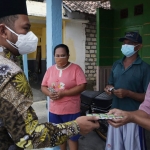 Bupati Gus Yani saat membagikan bantuan obat-obatan dan multivitamin gratis kepada warga Benjeng. foto: SYUHUD/ BANGSAONLINE
