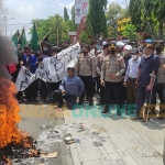 Aliansi Mahasiswa Mojokerto Raya berdemo di depan kantor Pemkot Mojokerto sambil bakar ban. Foto: YUDI EP/ BANGSAONLINE