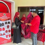 Ketua DPC PDIP Gresik, Mujid Riduan (kanan), menunjukkan batik produk Koperasi Berdikari Makmur Sejahtera PDIP Gresik. (Ist)