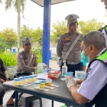 Petugas dari Polres Kediri saat melaksanakan tes urine kepada kru angkutan umum di Terminal Pare. Foto: Ist