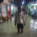 Warga Desa Banyutami menerobos jalan desa yang terendam banjir rob. Foto: Ist.