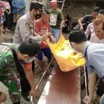 Petugas saat mengevakuasi jenazah kuli bangunan yang tersengat listrik di Dusun Dawung, Desa Bedug, Kecamatan Ngadiluwih, Kabupaten Kediri. Foto: Ist