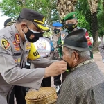 Kapolresta Banyuwangi Kombes Pol. Arman Asmara Syarifuddin sedang memakaikan masker. (foto: ist)