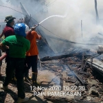 Petugas melakukan pembasahan di puing-puing kebakaran.