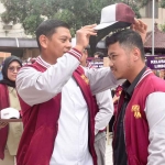 Wali Kota Kediri, Abdullah Abu Bakar, saat memakaikan topi kepada salah satu mahasiswa peserta KKN. Foto: Ist