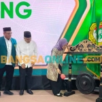 Dewi Mariya Ulfa saat memukul gong sebagai tanda pembukaan Musda ke-7 DPD LDII Kabupaten Kediri. Foto: MUJI HARJITA/BANGSAONLINE