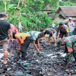 Petugas TNI-Polri dibantu warga sedang membersihkan puing-puing rumah sisa kebakaran.