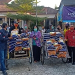 Lurah Pojok Erly Maya Muryati, bersama Abang Becak yang akan mengantarkan sembako. 