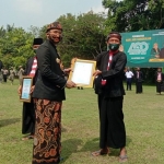 Bupati Bangkalan, R Abdul Latif Amin Imron, saat menerima penghargaan di halaman kantornya.