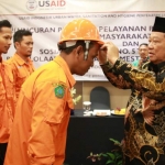 PELUNCURAN: Bupati Saiful Ilah mengenakan helm pada petugas sedot tinja berbasis online, di Favehotel Sidoarjo, Selasa (18/6). foto: ist