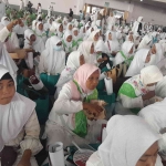 Warga asal Madura yang baru tiba di kampanye terakhir Khofifah-Emil di Jatim Expo Jalan A Yani Surabaya, Sabtu (23/11/2024). Tampak sebagaian dari mereka masih makan nasi yang disediakan panitia. Foto: Ist.