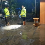 Dua anggota polisi saat di lokasi kejadian bencana banjir bandang, Minggu (25/2/2024).
