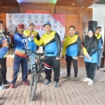 Sekda Gresik Achmad Washil didampingi Ketua AKD Duduksampeyan Suryadi dan Waka DPRD Nur Saidah menyerahkan hadiah sepeda gunung kepada peserta gowes yang dapat undian. foto: ist.