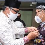 Ketua I Yayasan Gerontologi Abiyoso Jawa Timur, Dr. Edy Purwinarto saat memasangkan pin kepada pengurus perwakilan Kota Pasuruan.