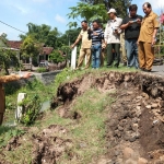 Wakil Bupati Nganjuk Marhaen Jumadi tampak sedang berdiri di pinggir tanggul yang longsor. Ia meminta segera dilakukan perbaikan secepatnya. foto: BAMBANG/ BANGSAONLINE