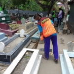 Seorang warga yang terjaring operasi yustisi mendapat sanksi membersihkan makam umum. foto: MUJI/ BANGSAONLINE