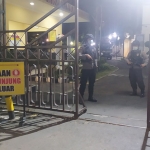 Personel bersenjata dan alat pelindung lengkap berjaga di gerbang masuk Polresta Banyuwangi.