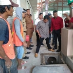 Anggota Komisi C DPRD Kota Batu didampingi instansi terkait saat mengecek saluran drainase dan akses jalan masuk pasar, Senin (20/1).