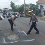 Petugas dari Satlantas Polres Mojokerto saat menandai jalan berlubang di perlintasan kereta api yang masuk kawasan Gunung Gedangan.