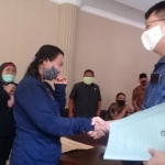 Yuliati dan pemilik apotek berjabat tangan tanda urusan sudah selesai.