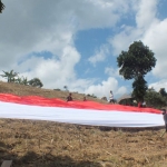 Bendera merah putih raksasa berukuran 150 x 15 meter yang dibentangkan di Bukit Tinggi Desa Lampeji Kecamatan Mumbulsari, Jember.