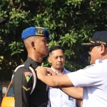 Kepala PT KAI Daop 7 Madiun, Suharjono, ketika menyematkan tanda kepada petugas Angkutan Nataru.