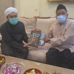 KH Fahmi Amrullah (Gus Fahmi, kanan) memberikan kumpulan kitab karangan Hadratussyaikh KHM Hasyim Asy