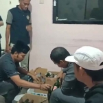 Petugas dari Polres Pamekasan saat membongkar isi kardus yang berisi Miras atau minuman keras berbagai merek.