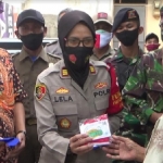 Kapolsek Wonoayu AKP Rohmawati Laila  ketika membagikan masker pada warga.