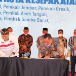 Bupati Gresik, Fandi Akhmad Yani (kanan), bersama Ketua BP2MI, Benny Rhamdani, saat menandatangani nota kesepakatan. Foto: Ist