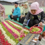 Khofifah saat melakukan tabur bunga ke makam suami dan orang tua di makam umum kawasan Wonocolo