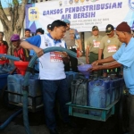 Bupati Sambari bersama Wabup Moh. Qosim dan Kapolres AKBP Boro Windu Danandito saat menyalurkan air bersih. foto: SYUHUD/ BANGSAONLINE