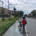 Salah seorang pengendara menunjukkan air dari gorong-gorong yang menggenangi jalan nasional, tepatnya di depan Ruko Gempol 9.